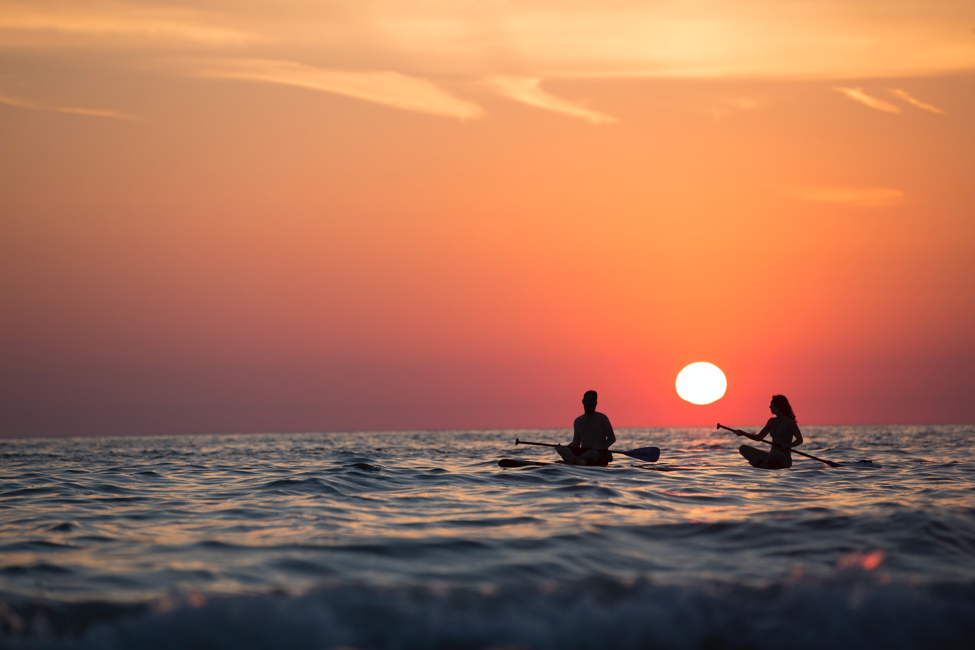 A man and a woman enjoying the Lahaina sunset by kayaking