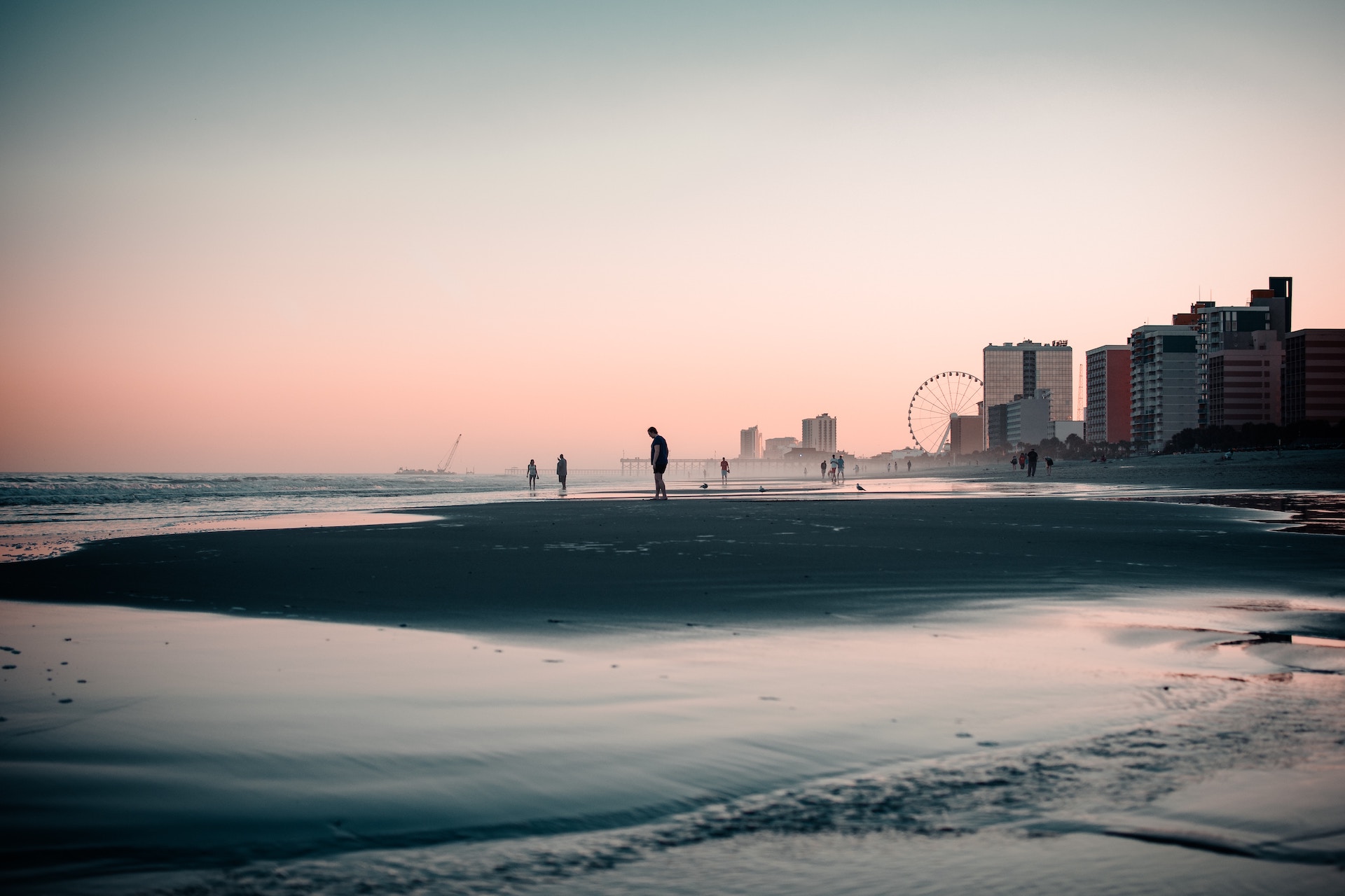People strolling along Myrtle Beach during sunset