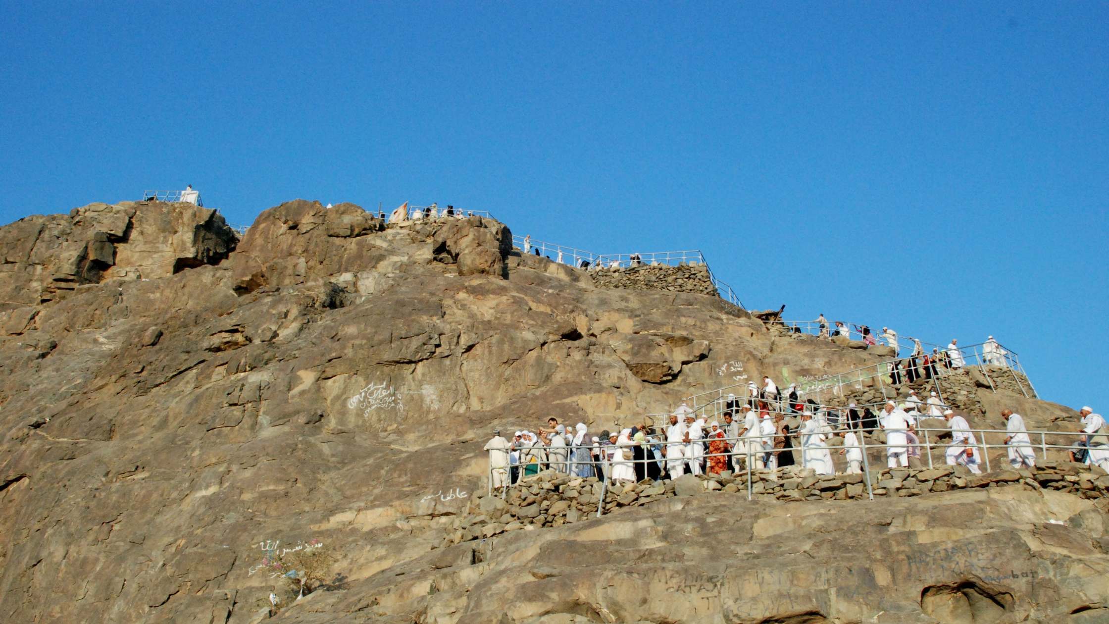 An image of a pilgrim tour in Greece, with people climbing Mount Olympus.