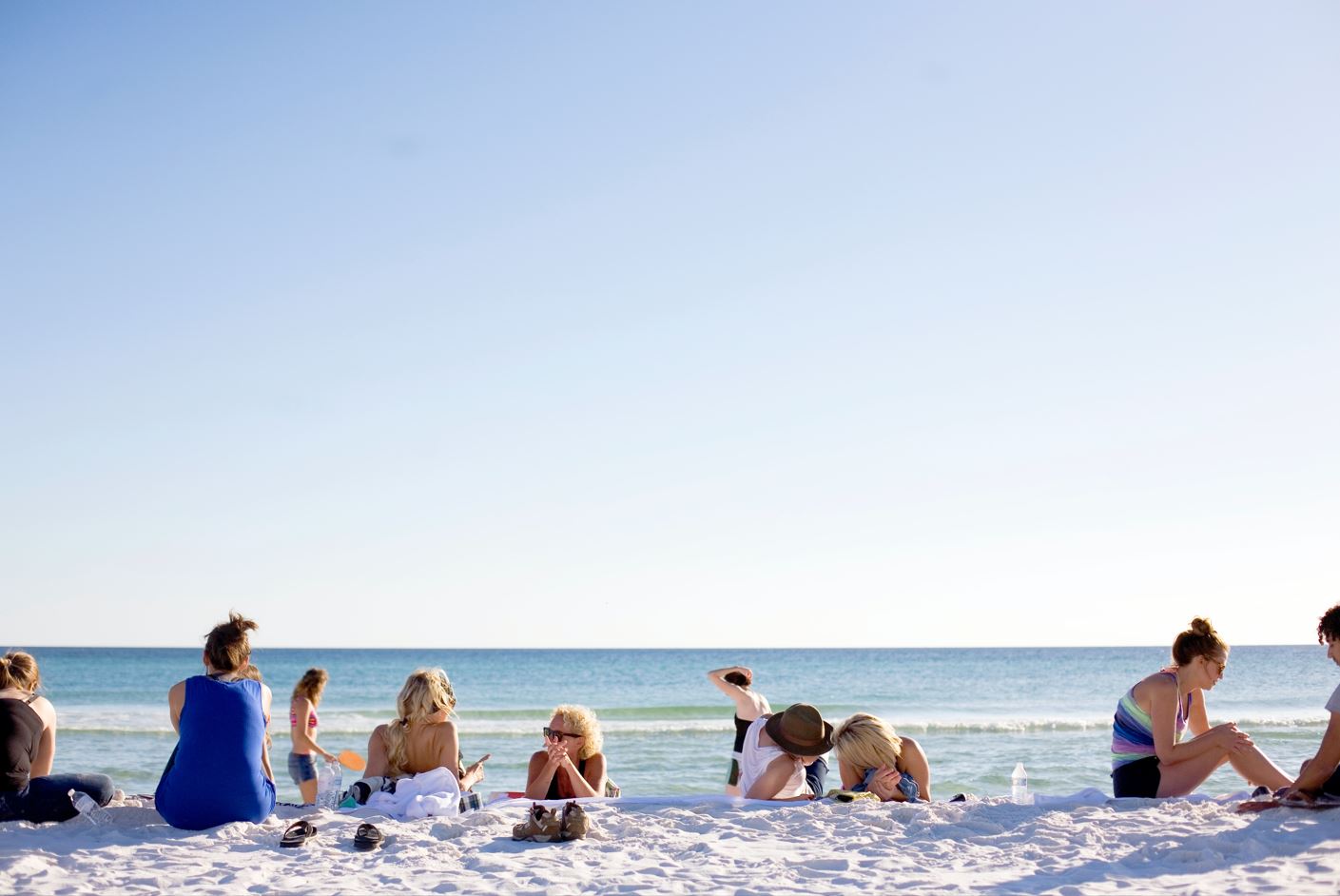 a group of people hanging out on the white sands of Destin's beaches